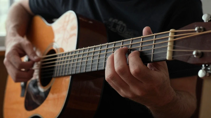 Manos de un músico ejecutando acordes sobre el mástil de una guitarra acústica.